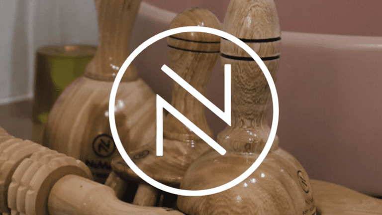 "NuVue Body Sculpting's logo with wooden lymphatic drainage tools, symbolizing their holistic approach to personalized wellness and lymphatic health."