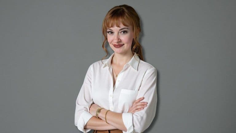 A woman wearing a white shirt and brown pants, representing leadership in healthcare innovation and collaboration.