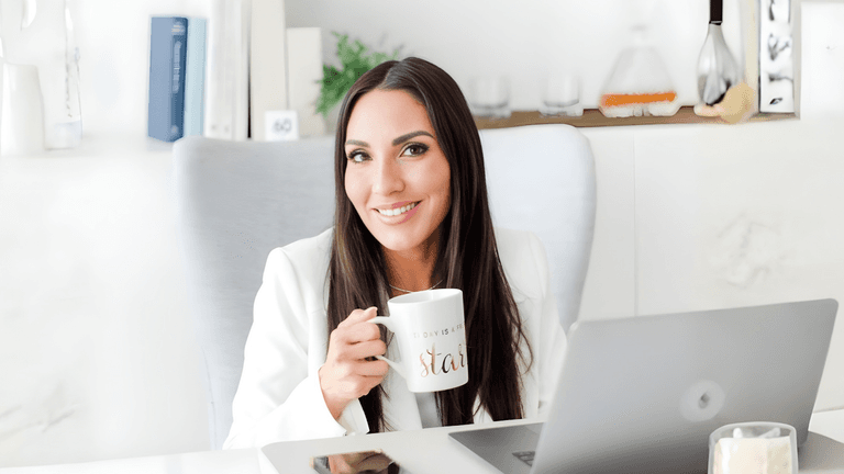 "Diana Marcela, LMFT, seated in her office with a laptop and coffee, representing her holistic, client-centered leadership at Curated Coaching and Counseling."