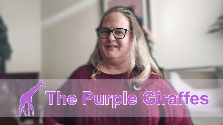 "A woman smiling and standing in front of a blurred background, wearing a maroon sweater and glasses, with the logo of 'The Purple Giraffes' in purple text and a giraffe icon on the left."