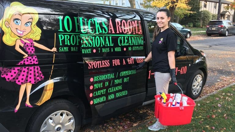Cleaning professional holding supply caddy beside branded 10 Bucks A Room service van in residential neighborhood.