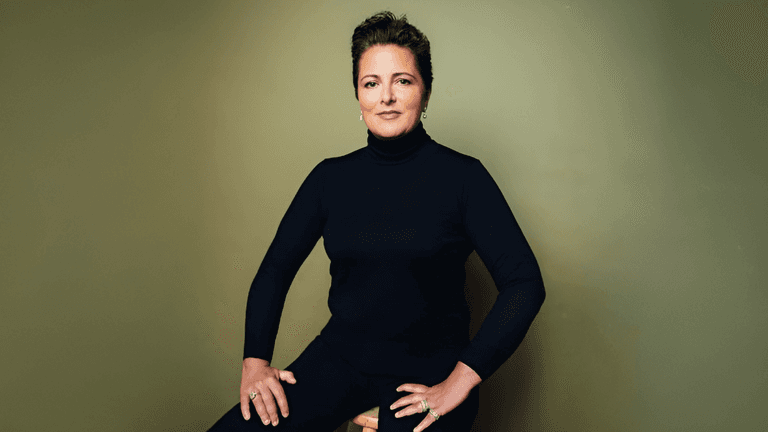 A confident woman wearing a black turtleneck poses, embodying strength and transformation, reflecting Josselyne Herman-Saccio’s coaching philosophy.