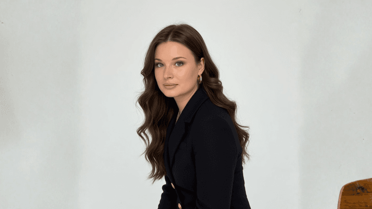A confident professional woman in a black suit, symbolizing resilience and leadership in scaling businesses without burnout.