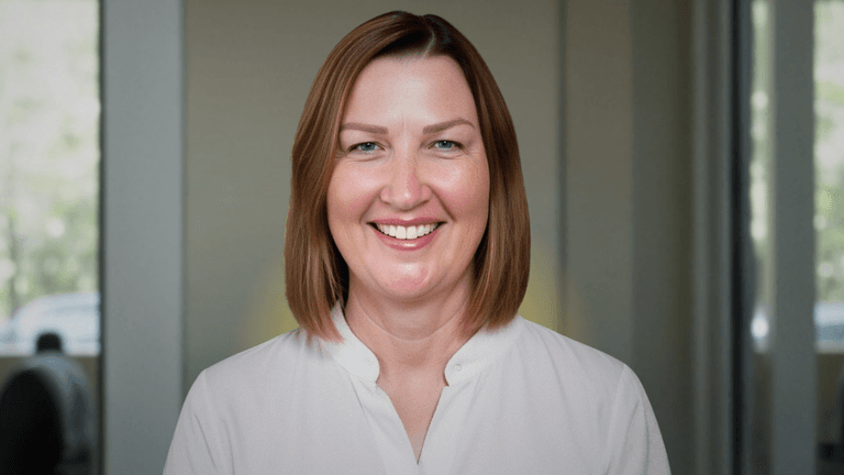 Renee West, founder of Intariq, smiling in front of a blurred office background, advocating for human-centered AI solutions.