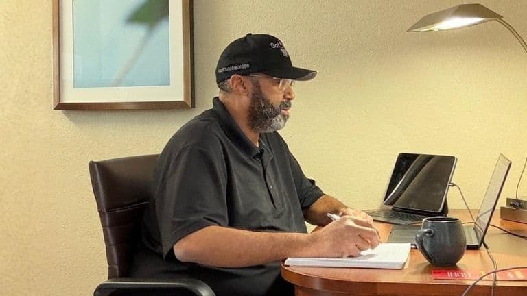 Ed Carter working at a hotel desk, managing Carter's Coffee Online with coffee, laptop, and handwritten notes.