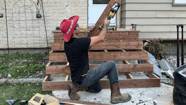 Carpenter Johnny builds wooden deck stairs in Winnipeg, showcasing craftsmanship and dedication to quality construction.
