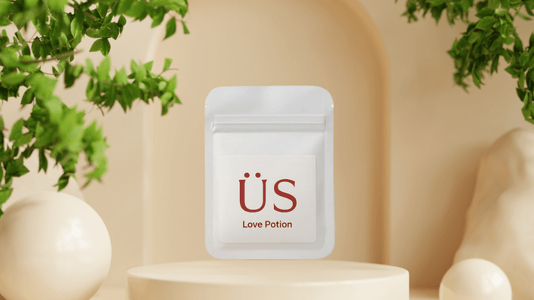 Minimalist pouch labeled "ÜS Love Potion" displayed on a pedestal, reflecting a luxury wellness brand's empowerment philosophy.