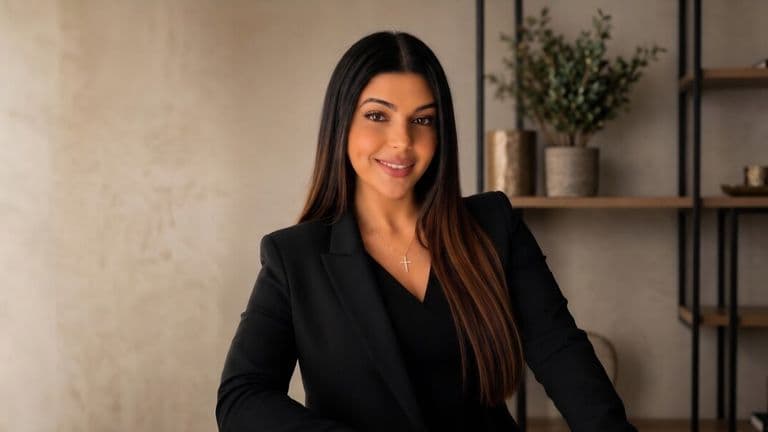 Rana Rofail Chahine posing in a black blazer in a modern office setting.