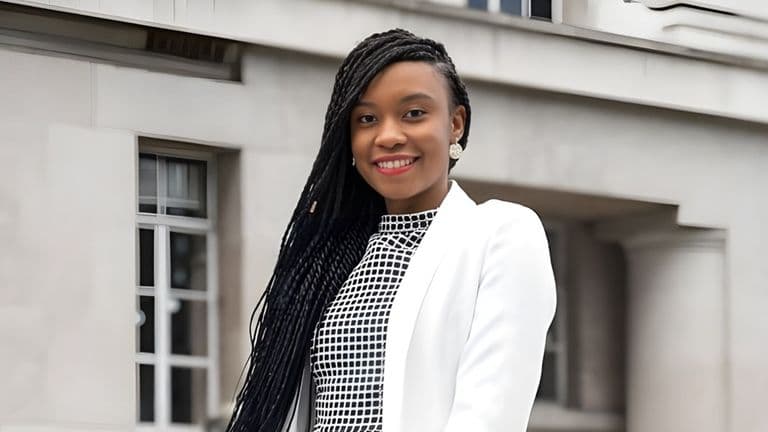 Dr. Amanda Mwale, founder of Resourced to Thrive, smiling confidently in a professional white blazer against a neutral background.