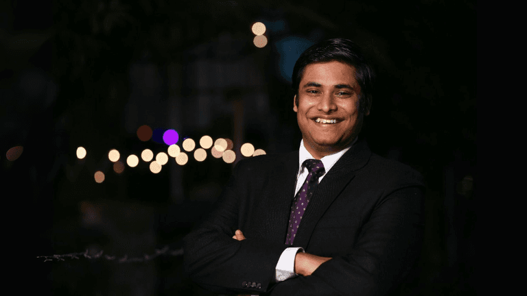 Vivek Rangabhashyam smiling in a suit, representing his inspiring journey of resilience, entrepreneurship, and community impact.