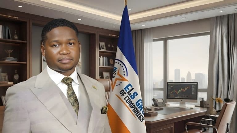 Simon El-Longwell, founder of ELS GROUP, standing confidently in his office with the company flag in the background.