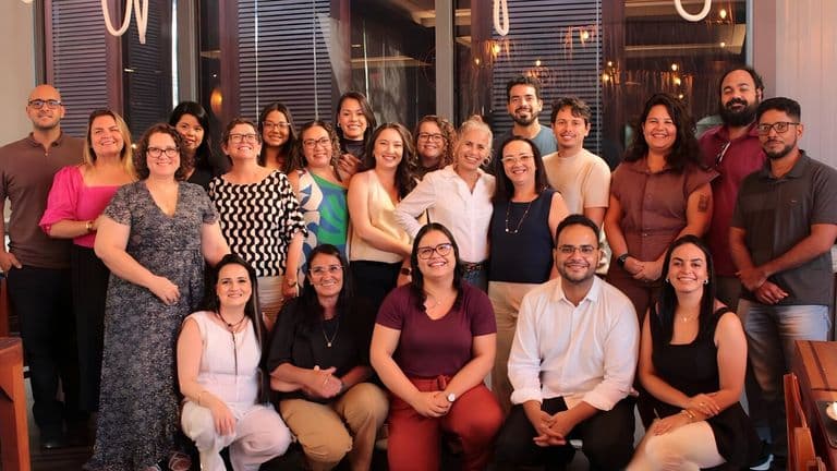 A joyful group of ENBER University faculty members posing for a photo in a restaurant, celebrating their top ranking in scientific production.