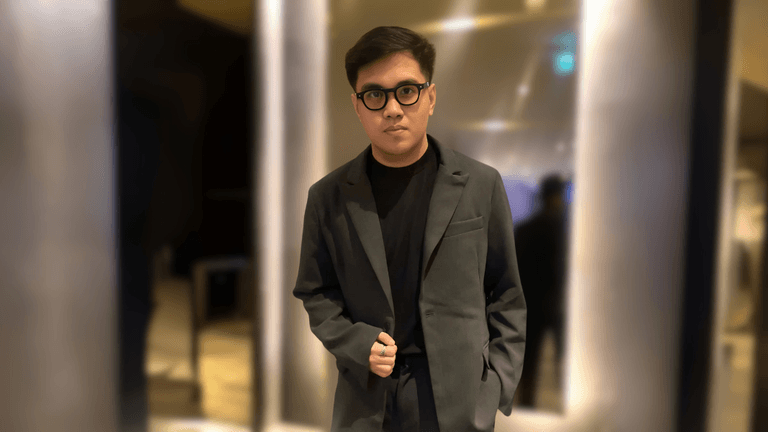 Neil Hernandez in a dark suit, standing confidently indoors, representing AI-driven marketing systems for service businesses.