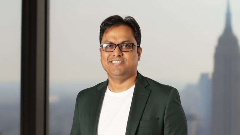 Dr. Srikumar Nayak, a pioneer in AI for financial crime prevention, standing in front of a city skyline.
