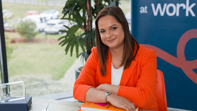 Lauren Neal in a professional setting with awards, showcasing Valued at Work’s leadership impact.