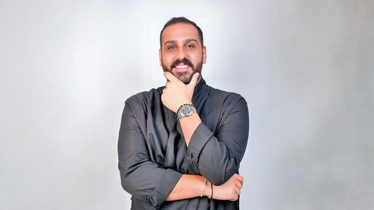 Elie El-Khoury, a data-driven digital marketing leader, confidently poses in a professional, creative setting with a watch.