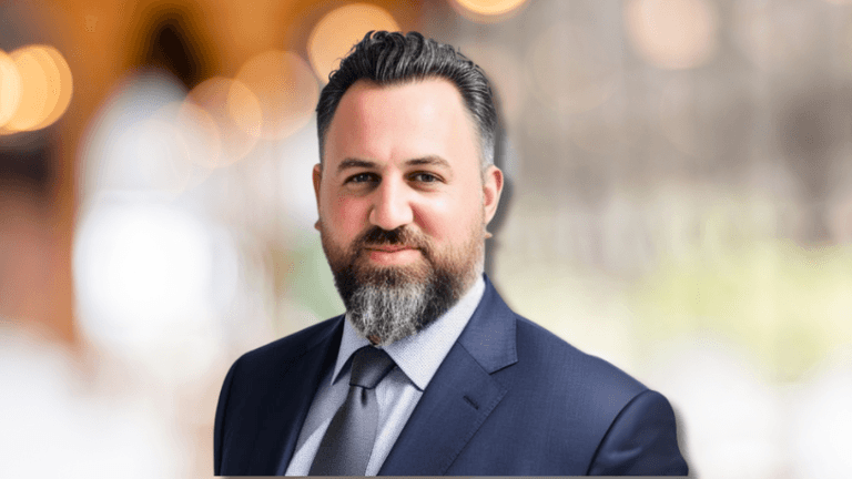 Tamir Leo Konortov, founder of KAL Solutions Group, in a suit, representing global tech outsourcing excellence.