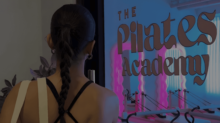 A person gazing at The Pilates Academy entrance, showcasing the academy’s modern, inviting vibe.
