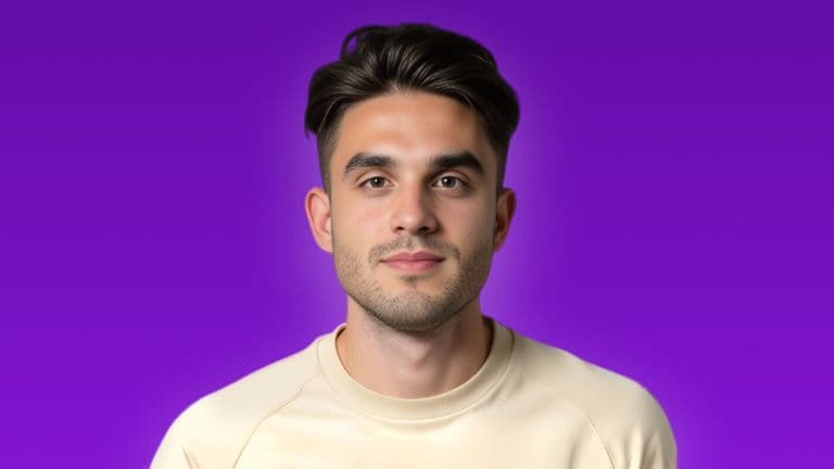 A man in a white shirt smiles at the camera, embodying confidence and approachability in a professional setting.