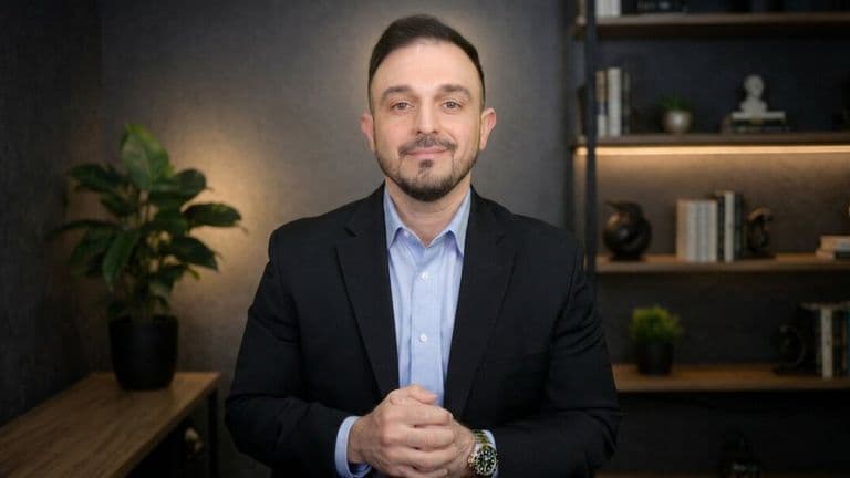 Adam Shoar in business attire standing in an office, promoting AI-supported automotive finance training.