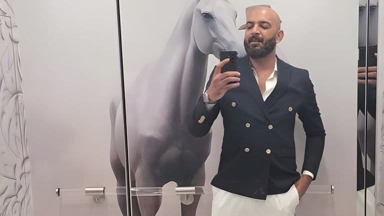 Ehtasham Malik, CEO of Mayfair Group, posing in a luxury setting with a modern suit, reflecting his innovative vision.