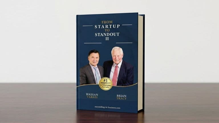 Book cover of “From Startup to Standout II” featuring Hassan Varasi and Brian Tracy on a blue background.