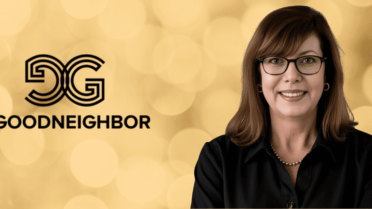 Portrait of a woman with glasses and a black blouse, smiling next to the "GoodNeighbor" logo against a golden bokeh background.
