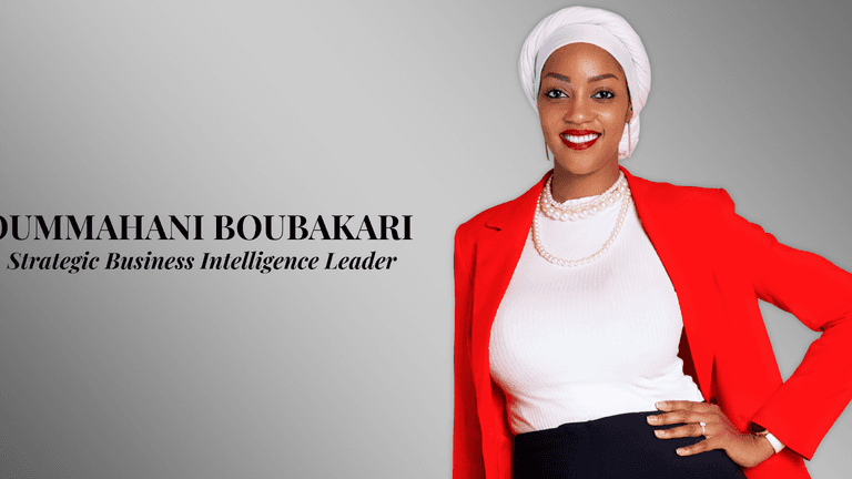 Portrait of Oummhani Boubakari, a Strategic Business Intelligence Leader, wearing a red blazer, white top, and pearl necklace.