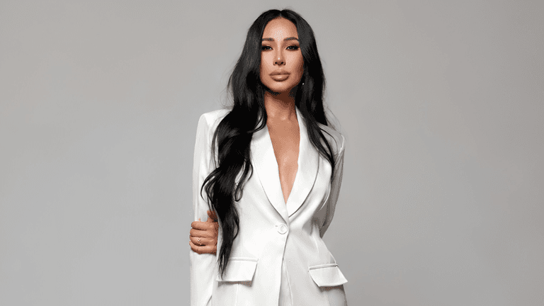 Victoria Tik wearing a white blazer against a neutral gray background.