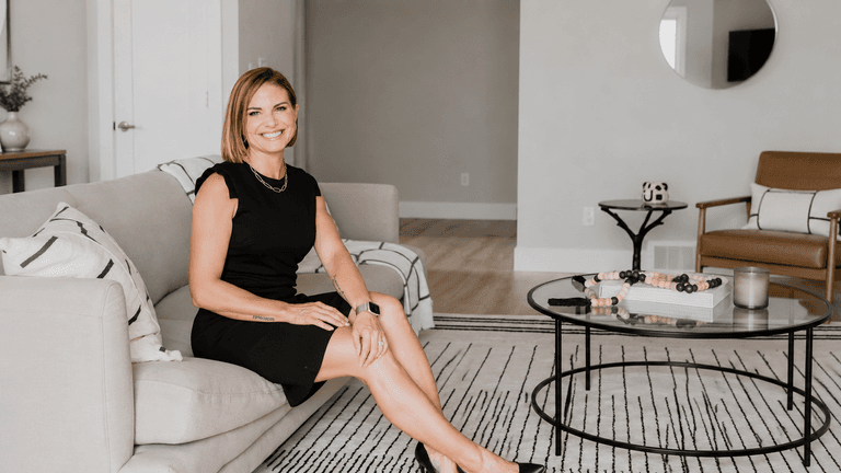 Angela Porrelli seated in a staged living room during a real estate consultation.