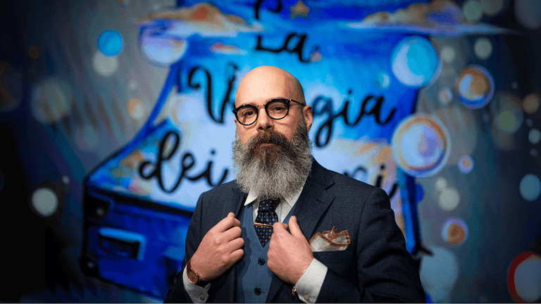 "Matteo Valléro, an esteemed Italian journalist and columnist, stands confidently in front of a colorful background, embodying the ethical values of 'Made in Italy' business culture."