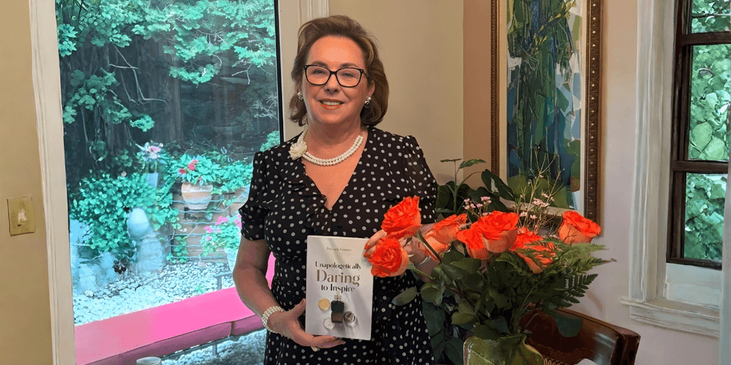 "Petronely Grindea, bestselling author and wellness innovator, holding her memoir 'Unapologetically Daring to Inspire' while promoting women’s empowerment and inner strength."