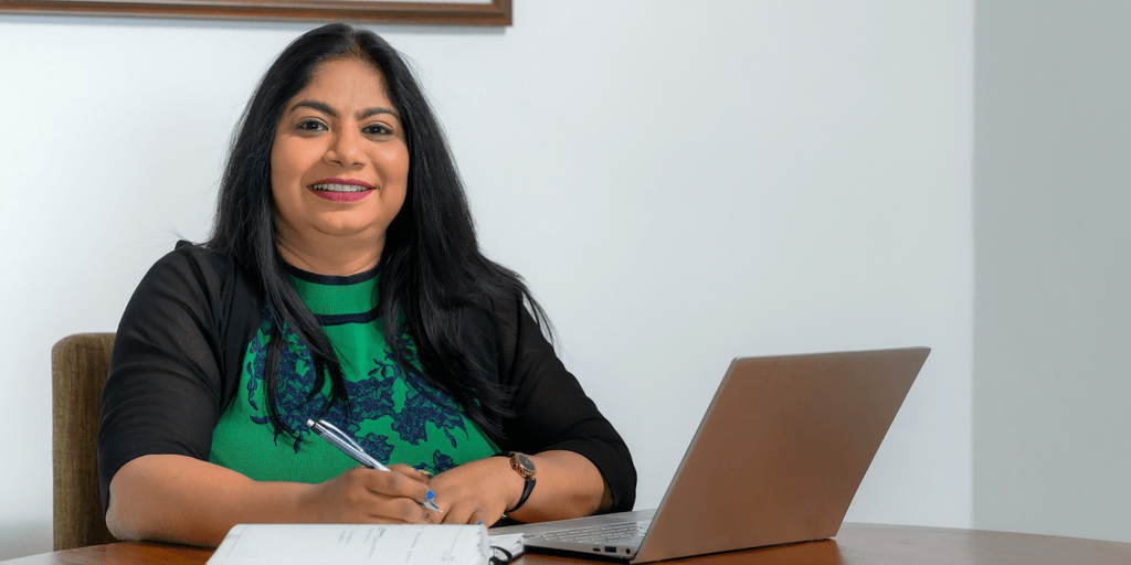 "Chamila Udagedara, CEO of Capital Legal Solicitors, providing compassionate, integrity-driven legal services while working confidently at her desk with a laptop."
