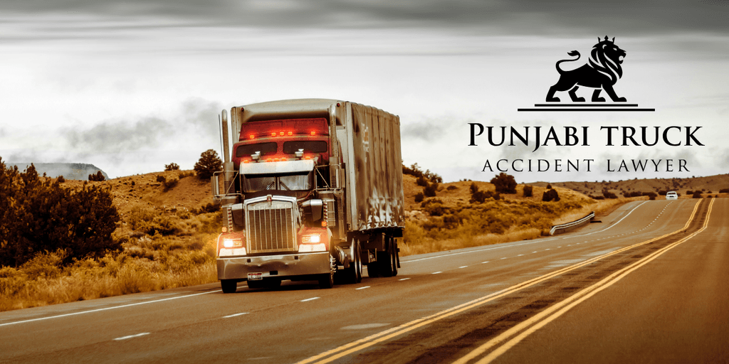 Truck driving on a highway with Punjabi Truck Accident Lawyer logo, symbolizing advocacy for justice in truck accident cases.