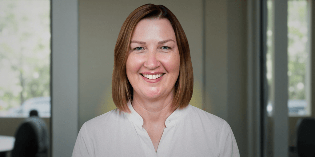 Renee West, founder of Intariq, smiling in front of a blurred office background, advocating for human-centered AI solutions.