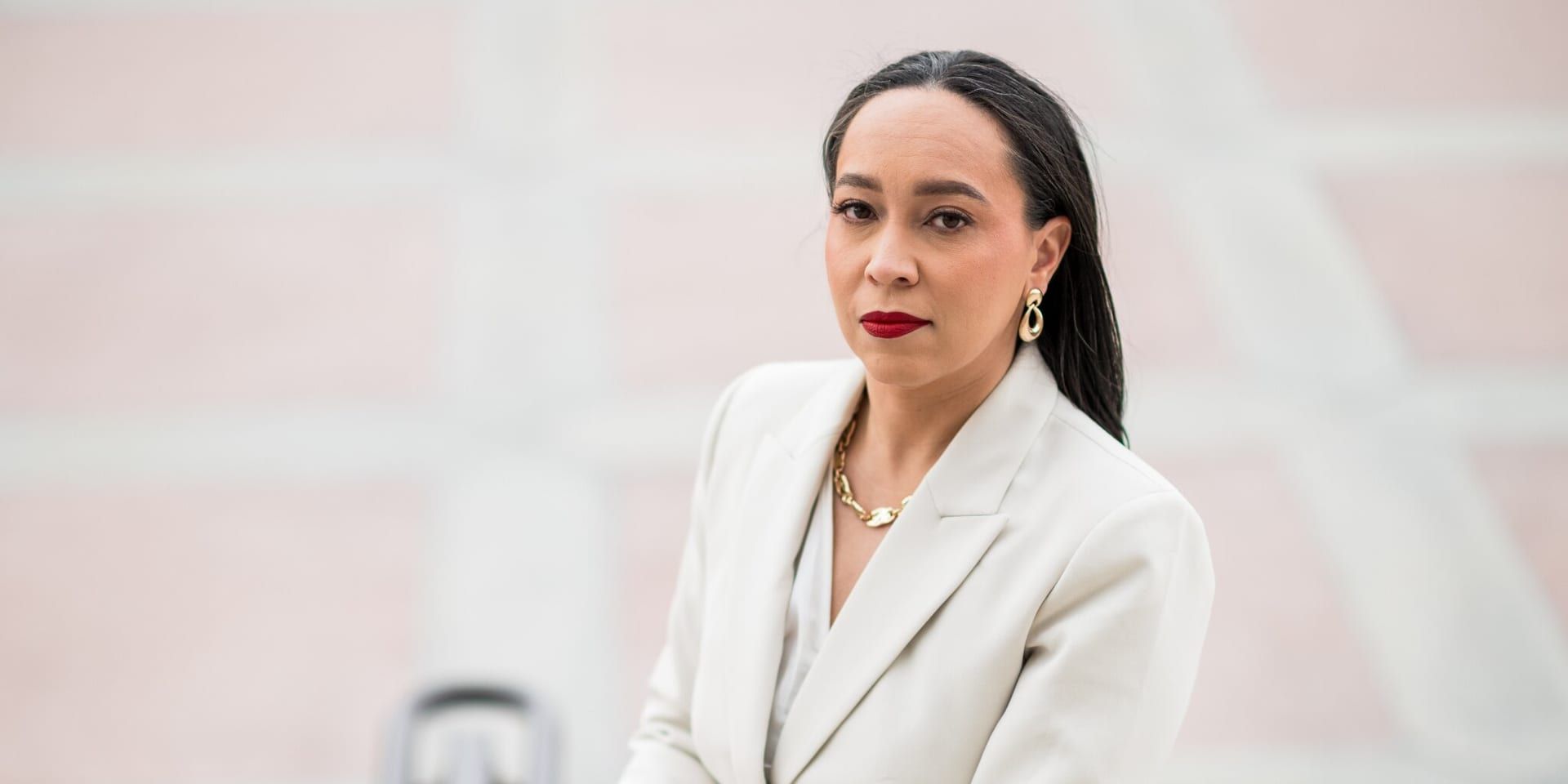 Tina Patterson in a white suit with red lipstick, exuding confidence as she discusses strategic legal counsel for leaders.