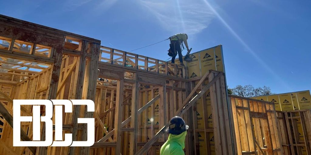 Two individuals engaged in construction work on a house, showcasing Bowser Construction Group's commitment to efficiency.