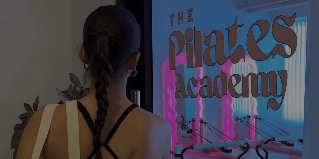 A person gazing at The Pilates Academy entrance, showcasing the academy’s modern, inviting vibe.