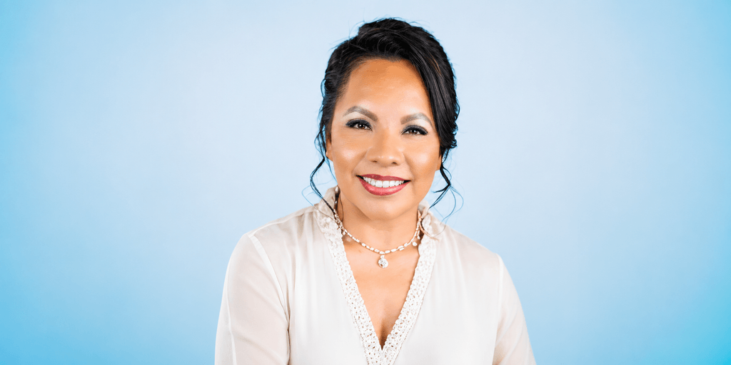 Dr. Maricela Soberanes smiling in a white blouse against a blue background.
