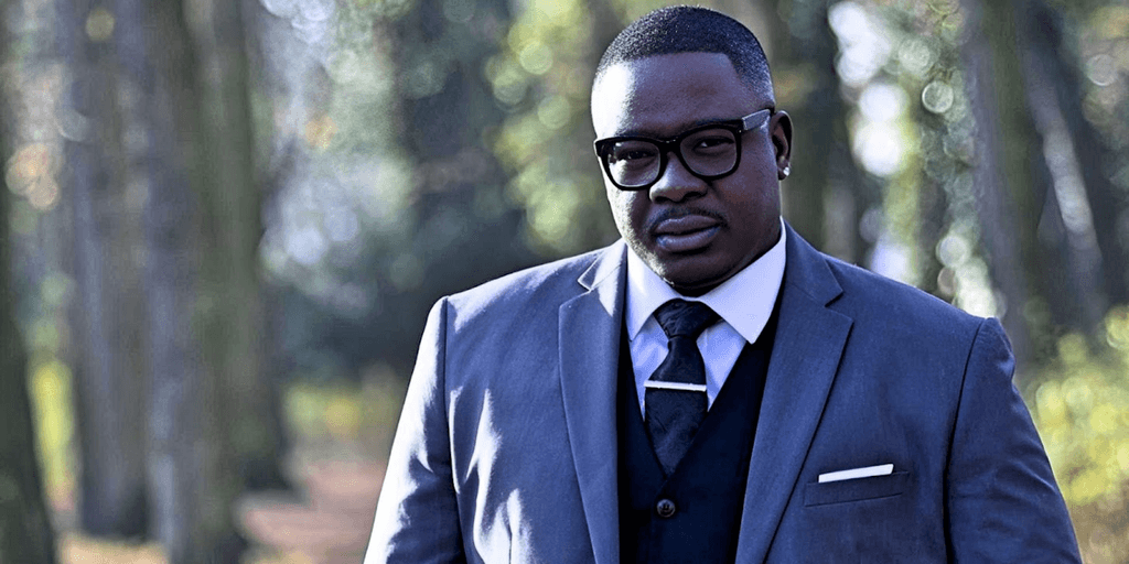 Freddy Will, CEO of Badson Publishing, stands confidently in a suit, embodying his global influence in music and literature.
