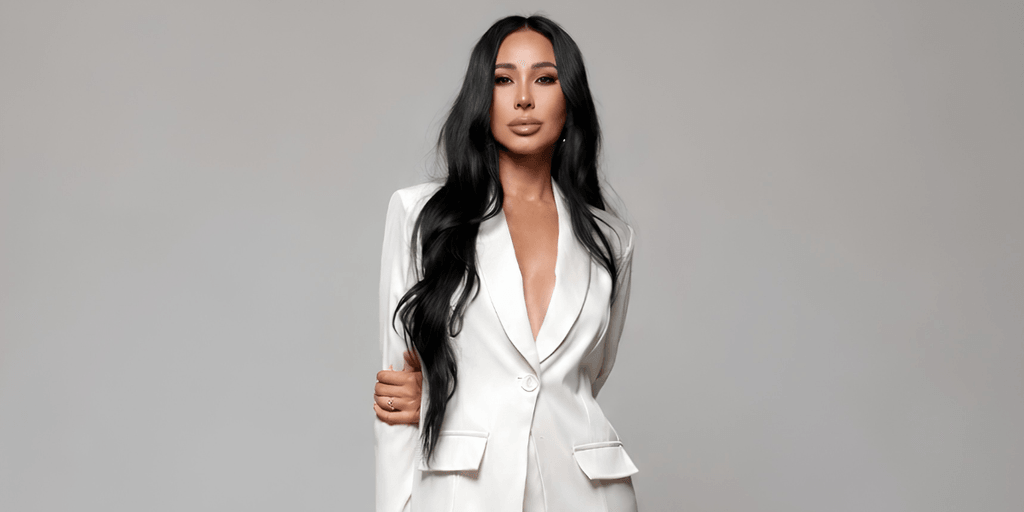 Victoria Tik wearing a white blazer against a neutral gray background.