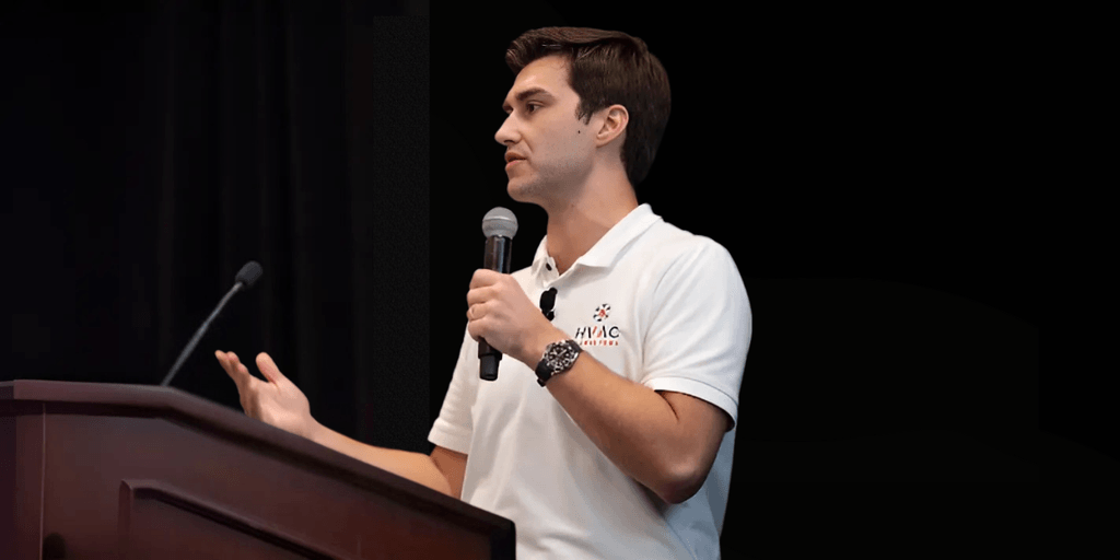 Alex Van Leeuwen speaking at a conference, sharing insights on HVAC marketing strategies and business growth.