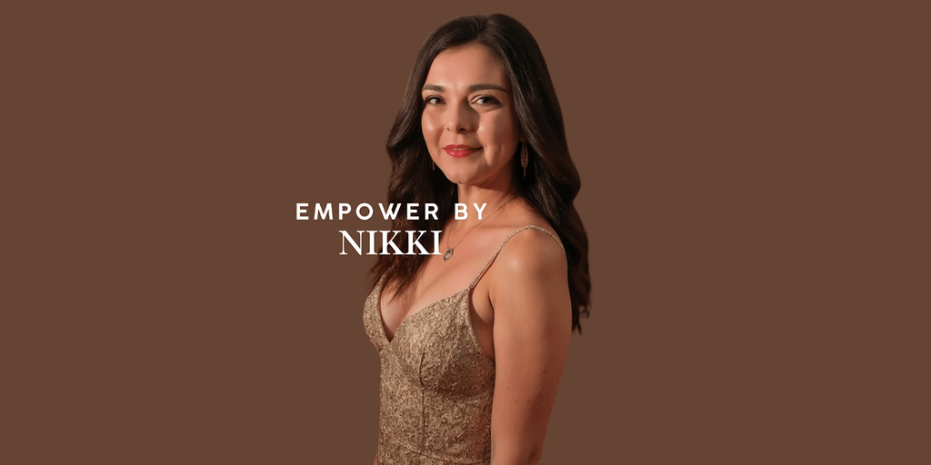 A woman in a gold dress stands confidently, smiling with a warm expression. The text 'EMPOWER BY NIKKI' is displayed above her name, Nikki, symbolizing empowerment and resilience. The background is a simple brown shade, highlighting her elegance and strength.