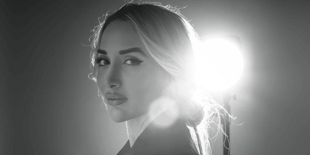 Black and white portrait of a confident woman with long hair, gazing