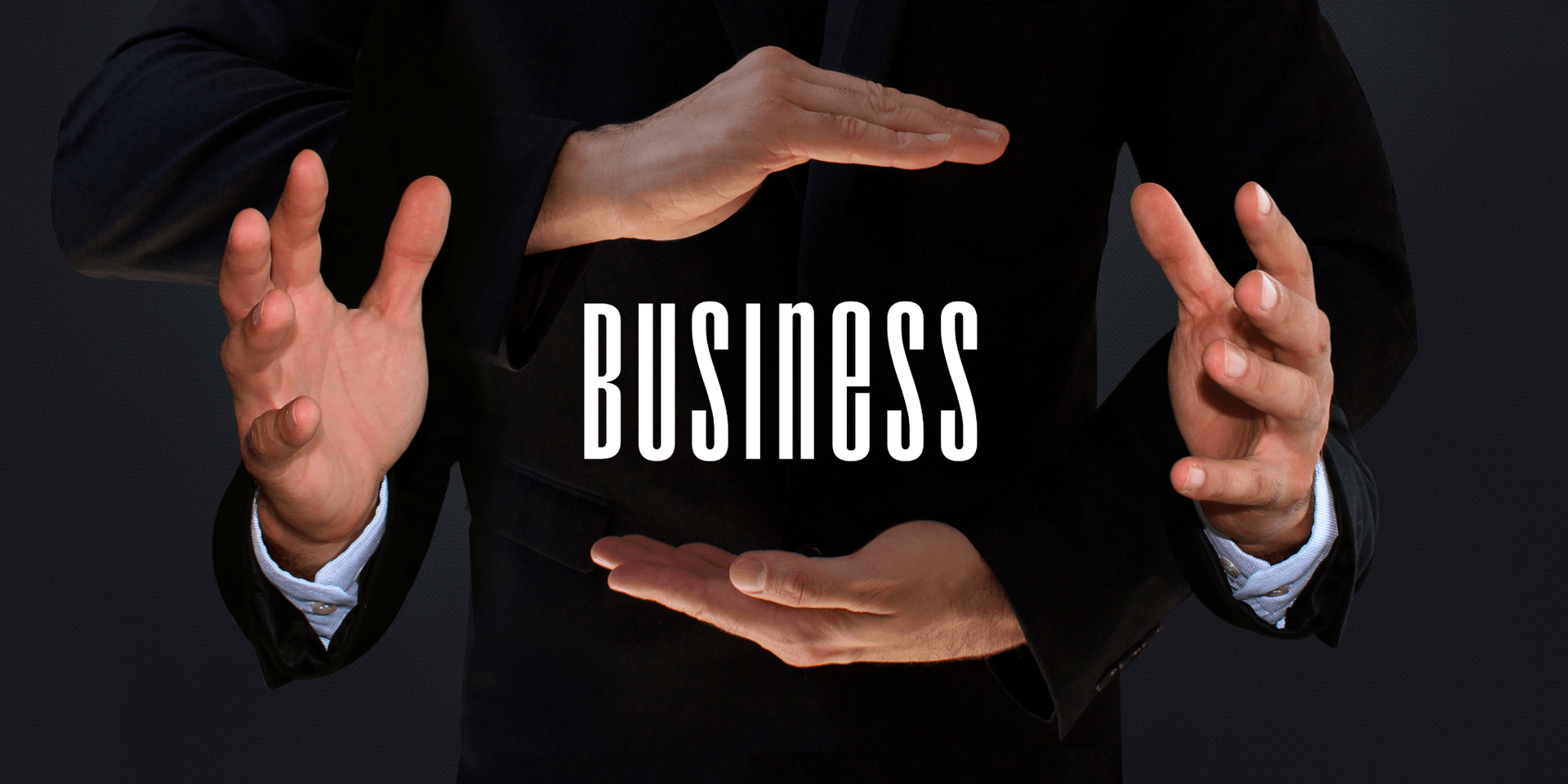 Two hands framing the word "BUSINESS" in a professional setting.