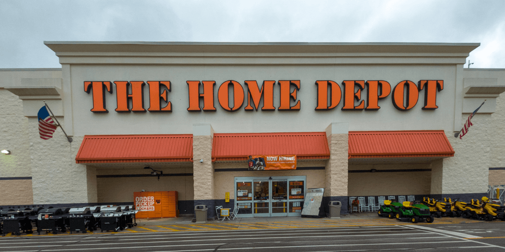 Exterior of a Home Depot store with landscaped parking and equipment displays outside
