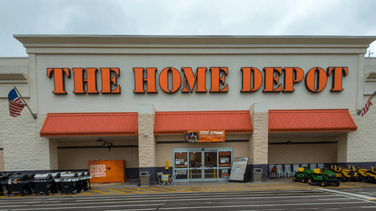 Exterior of a Home Depot store with landscaped parking and equipment displays outside