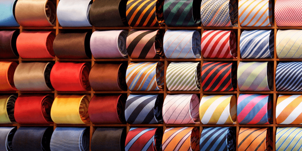 A colorful display of neatly arranged ties in a wooden wall rack