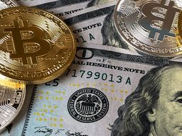 Golden Bitcoin coins on top of U.S. dollar bills with Benjamin Franklin's portrait