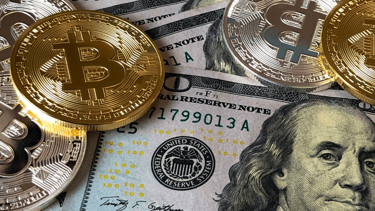 Golden Bitcoin coins on top of U.S. dollar bills with Benjamin Franklin's portrait